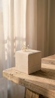 Elegant beige fabric jewelry box with golden crown decoration on rustic wooden table in soft natural light for luxury storage and home decor.