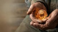 Senior man with weathered hands holding golden ring, symbolizing wealth, inheritance, jewelry investment, and precious metal value for financial and lifestyle concepts.