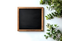 Empty wooden framed chalkboard with green foliage on white background, perfect for adding custom text or menu designs.