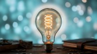 Glowing vintage Edison light bulb with warm filament on wooden surface against blurred bokeh background. Creative inspiration and innovation concept for business presentations.