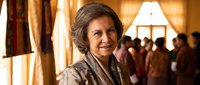 Mature Caucasian businesswoman smiling confidently in elegant hotel lobby with warm lighting and blurred people in background for corporate presentations.