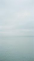 Serene seascape with calm turquoise waters meeting overcast sky, conveying tranquility and minimalist coastal atmosphere for travel, wellness, and editorial projects.