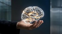 Businessman hand holding transparent glowing brain with neural networks floating above palm in modern office environment for artificial intelligence concepts.