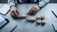 Business professional arranging wooden blocks with arrow symbols on desk, strategic planning and direction concept for corporate growth and decision making.