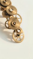 Golden brass mechanical gears and cogs arranged on white background for engineering, clockwork, machinery and industrial design concepts.
