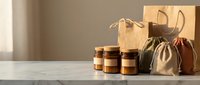 Eco-friendly shopping bags with kraft paper and fabric pouches displayed with glass jars on marble surface, sustainable packaging and zero-waste lifestyle concept.