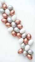 Elegant metallic Easter eggs in rose gold, silver and white arranged on neutral background for spring holiday celebrations and festive decorations.