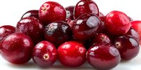 Fresh ripe cranberries with water droplets, showcasing vibrant red color and glossy surface for food photography, cooking blogs, and holiday recipe content.