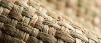 Natural wicker basket weave texture with intricate braided pattern in warm brown tones for rustic home decor and craft projects.