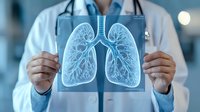Medical professional in white coat holding up digital lung x-ray scan showing detailed pulmonary system visualization with blue holographic glow effect in hospital setting.