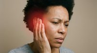 African American woman experiencing severe headache pain holding temple with hand showing red inflammation area for medical health concept.