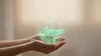 Hands holding glowing green energy orb with mystical light effects for healing, wellness and spiritual concepts in soft neutral background.