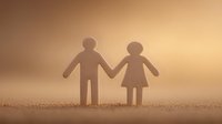 Wooden figures of couple holding hands silhouetted against warm golden background, symbolizing love, partnership, and human connection.