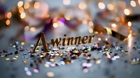 Golden word winner surrounded by sparkling confetti and blurred bokeh lights creating magical celebratory atmosphere on dark background. Success concept.
