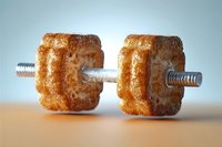 Creative fitness concept showing dumbbell made from baked cookies with metal bar, representing balance between exercise and indulgence on wooden surface.