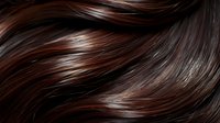 Luxurious dark brown hair with auburn highlights flowing in smooth, glossy waves showing healthy texture for beauty and haircare advertising.