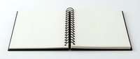 Open spiral-bound notebook with blank white pages on neutral background, ready for writing, sketching, journaling, or creative projects and design work.