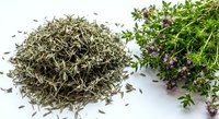 Dried thyme herbs pile with fresh flowering thyme sprigs on white background. Culinary seasoning spice for cooking and natural medicine ingredient.