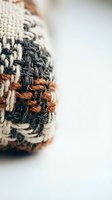 Handmade woven textile with natural fiber threads in earth tones showing detailed craftsmanship and organic texture for artisan projects and home decor.