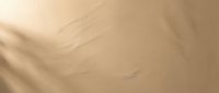 Soft beige fabric texture with gentle folds and creases creating elegant shadows and highlights for luxury fashion and interior design backgrounds.