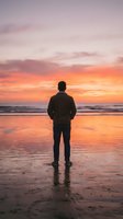 Man in business casual attire standing alone on wet beach sand facing ocean during golden hour sunset, reflecting on life decisions and personal growth opportunities.