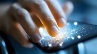 Young adult hand touching glowing digital tablet surface with sparkling light effects, representing technology interaction, digital innovation, and modern communication for web and app design.