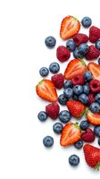 Fresh mixed berries including strawberries, blueberries and raspberries arranged on white background. Isolated produce for food and beverage design.