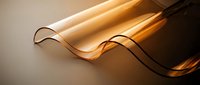 Translucent amber wave panel with smooth curves glowing in warm golden light, showcasing elegant material texture on neutral background.