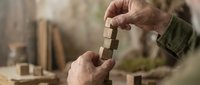 Skilled craftsman hands carefully shaping wood with traditional chisel tool in workshop, showcasing artisan woodworking techniques and handmade craftsmanship.