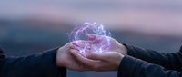 Hands holding glowing digital brain with electric neural networks against blurred sunset sky background representing artificial intelligence and innovation.
