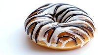 Glazed donut with white and dark chocolate drizzle on white background, appetizing pastry dessert isolated for food photography and menu design.