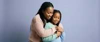 African American mother and daughter embracing in warm hug showing family love and connection on purple background for parenting and relationship concepts.