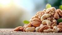Mixed raw nuts including almonds, cashews and walnuts on wooden surface with soft natural lighting and green leaves, macro food photography for healthy eating concept.