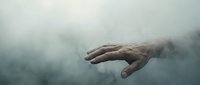 Mysterious hand emerging from dense fog or smoke creating dramatic atmospheric effect for horror thriller or supernatural themed projects.