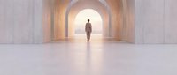 Man in business casual attire walking through modern arched corridor with warm lighting, symbolizing career progression, opportunity, and professional journey toward success.