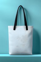 White canvas tote bag with black handles on turquoise background for shopping, branding and eco-friendly lifestyle mockup design projects.