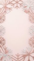Paper snowflakes frame in soft pink tones creating elegant winter border with empty center space for text or design elements on pastel background.