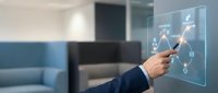 Businessman in dark suit touching interactive digital interface with connected network icons and data symbols on transparent screen in modern office environment with blurred background.