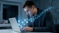 Young Caucasian businessman working on laptop with glowing digital network connections and data streams in modern office environment at night.