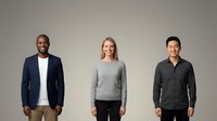 Three diverse business professionals standing together in casual corporate attire against neutral background for workplace diversity and teamwork concepts.