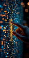 Finger touching digital data visualization with glowing orange and blue light effects, creating futuristic technology concept against dark background with bokeh.