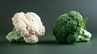 Fresh cauliflower and broccoli heads on dark background for healthy cooking and nutrition concepts in kitchen and restaurant use.