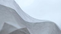 White tissue paper with soft flowing curves and delicate translucent texture creating elegant waves and folds for packaging and craft projects.