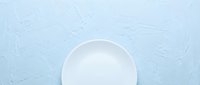 White empty plate on light blue textured surface, isolated and ready for food styling, product mockups, culinary design, restaurant menus, and dining concepts.