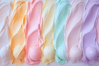 Smooth swirls of pastel ice cream in rainbow colors - white, orange, pink, yellow, mint and purple arranged in parallel rows creating soft textured pattern.