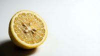 Fresh lemon half showing detailed pulp texture and seeds on clean white background. Natural citrus fruit cross-section for healthy cooking and beverage concepts.