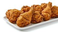 Crispy fried chicken pieces with golden-brown coating arranged on white plate, ready for food service, restaurant menus, or culinary content.