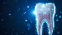 Glowing digital tooth with sparkling particles on blue background for dental care and oral health concepts in modern medical technology design.