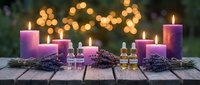 Purple candles with lavender sprigs and essential oil bottles on rustic wooden table with warm bokeh lights creating peaceful spa atmosphere for relaxation.