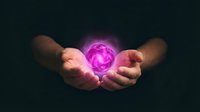 Hands holding glowing pink energy orb with magical light effects on dark background for spiritual and mystical design concepts.
